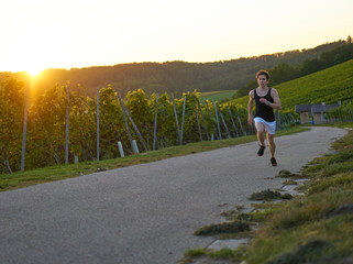 dynamic jogger Runner jogging  young attractive shorts vineyards sportsman sunset greenery nature...
