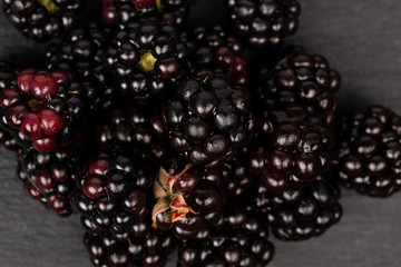 Lot of whole fresh black blackberry flatlay on grey stone