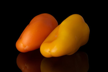 Group of two whole fresh pepper isolated on black glass