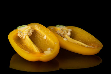 Group of two halves of fresh pepper isolated on black glass