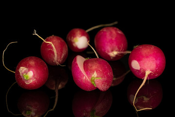 Group of five whole two halves of fresh red radish one sliced isolated on black glass