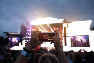 Close up of photographing with smartphone during a concert.