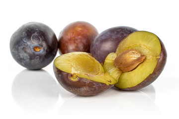 Group of three whole two halves of sweet purple plum isolated on white background