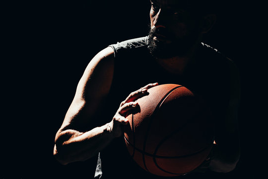 Dramatic portrait of basketball player over dark background