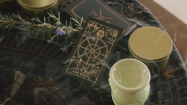 Slow zoom into tarot card amidst incense smoke on a psychic medium's altar