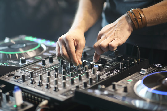 DJ using sound controller to mix music