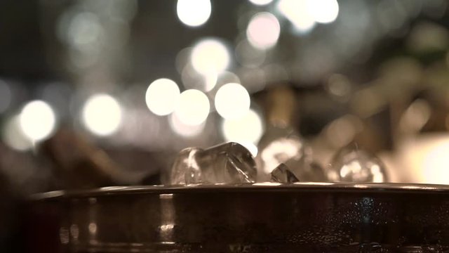 Iron Ice Pail With Chilling Champagne Bottles On A Bar Counter At A Fancy Restaurant, Close-up. Stainless Steel Ice Bucket For Drinks Covered With Water Drops Condensation In Soft Evening Lighting.