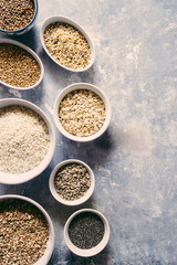 Variaty of raw cereals  on  bowls, top view flat lay,lentils, bulgur and quinoa, hemp seed,sunflower seeds ,brown rice, rice, healthy food concept , clean eating and detox concept.