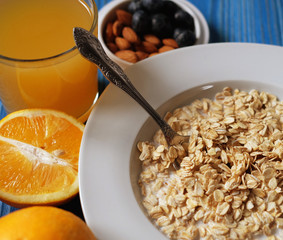 Breakfast with oatmeal and orange juice on blue wooden background