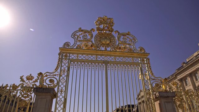Pan shot of golden gate to the Palace of Versailles in France on background of blue sky without clouds