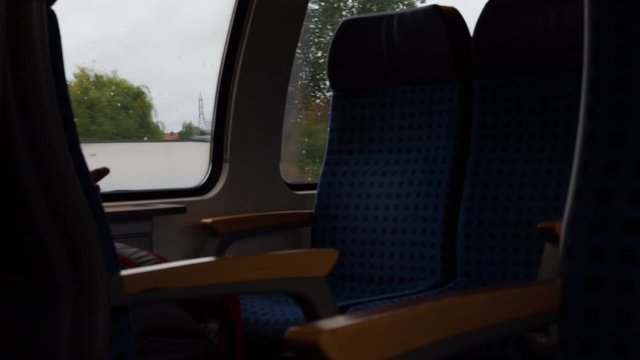 Empty windows seat in a train traveling through the city during the day. Missing passenger.