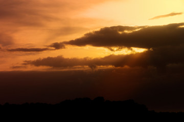 A scenic warm toned view of an overcast sunset.