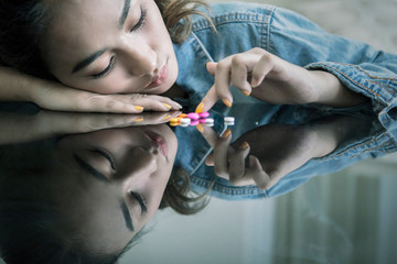 Female teenage looks addicted while counting drugs - obrazy, fototapety, plakaty