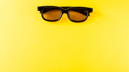 3D black glasses on yellow background