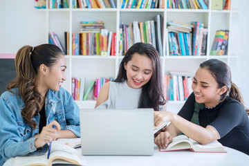 Group of female students using a laptop in library