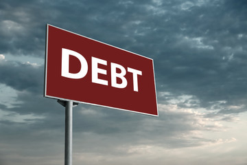 Billboard with word DEBT against cloudy sky