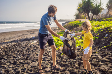 Dad and son are cleaning up the beach. Natural education of children