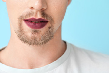 Young transgender woman on color background, closeup