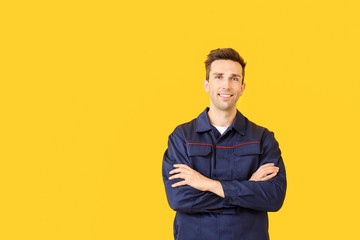 Male car mechanic on color background