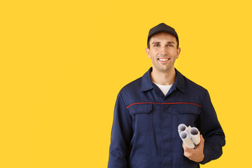 Male car mechanic with drawings on color background