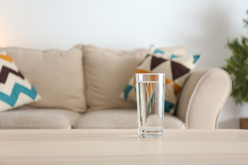 Glass of fresh water on table in room