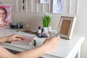 Woman with glass of fresh water at table
