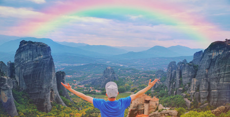 Man traveler praying at sunset mountain summit enjoying aerial epic rainbow view raised hands Travel lifestyle success relaxation. Emotional vacations, outdoor adventure freedom harmony nature concept © raisondtre
