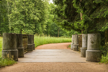 The bridge in Catherine’s park in the royal village leading to the road to the right with green trees in Saint Petersburg