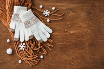 木目背景に手袋とマフラー。冬支度と雪