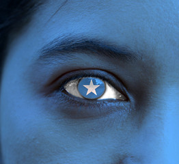 Human face painted Somalia flag with white star on the center of eye or eyeball.