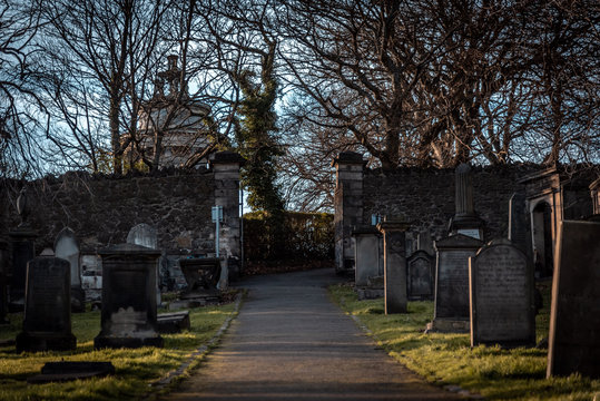 EDINBURGH, SCOTLAND DECEMBER 14, 2018: path to an entrance of a graveyard with a open wrought-iron gate