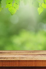 Wooden table and blurred green leaf nature in garden background. 