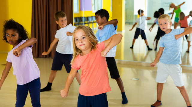 Portrait Of Smiling Children Practicing Sport Dance In Modern Dance Hall