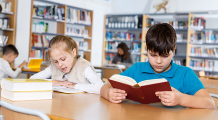 School friends reading books in library