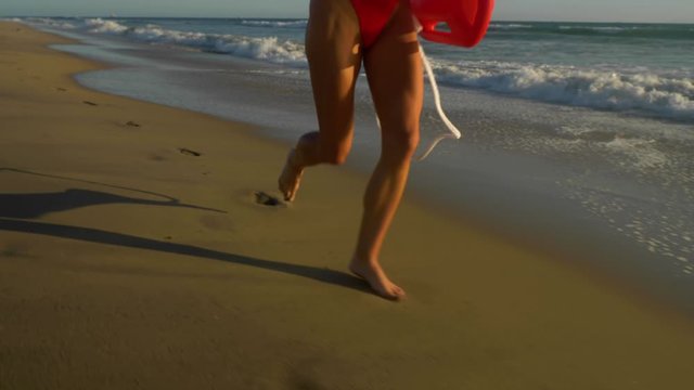 Female lifeguard running along the beach