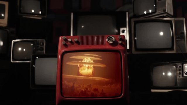 Nuclear Testing and Atomic Bomb Explosion on a Retro TV that Explodes and Breaks. Blue Dark Tone. Editorial use only. Contains public domain U.S. Army material displayed on screen.
