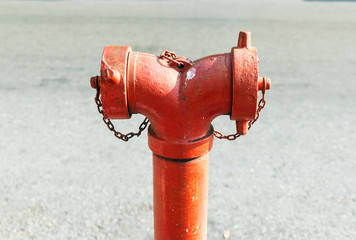 Close up red standpipe hydrant system for fire prevention and fighting standing on footpath with...