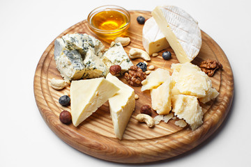 different cheeses sliced on wooden board