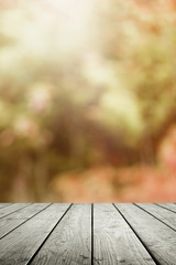 Wooden table and blurred bokeh autumn background.
