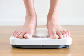 Legs of women standing on scales weight background fitness room. Concept of healthy lifestyle and sport
