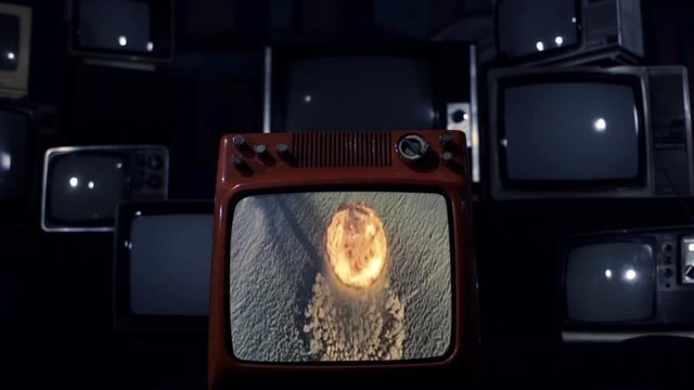 Nuclear Testing and Atomic Bomb Explosion on a Retro TV that Explodes and Breaks. Blue Dark Tone. Editorial use only. Contains public domain U.S. Army material displayed on screen.
