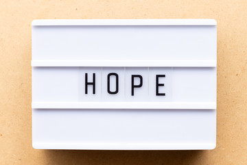 Lightbox with word hope on wood background