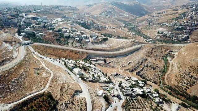 Aerial footage over East Jerusalem Palestinian neighborhoods with security fence Drone View over Judea Desert and arab neighborhoods in East jerusalem