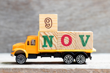 Truck hold letter block in word 9nov on wood background (Concept for date 9 month November)