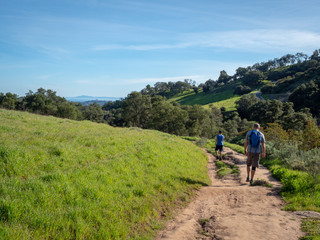 Father and son hiking on Jesusita Trail with panoramic view of ocean and Channel Islands, Santa Barbara, California, USA - obrazy, fototapety, plakaty
