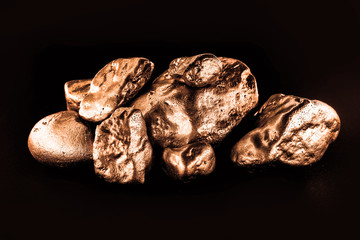 bronze nugget precious stone on black background. Concept of finance, luxury or wealth.