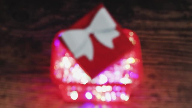 festive season shopping concept Christmas gift box in shopping basket with fairy lights inside going from out of focus bokeh to in focus