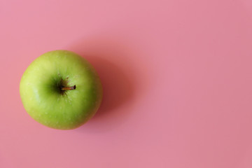 A ripe green apple fruit isolated on pink background with copy space for text. Top view.