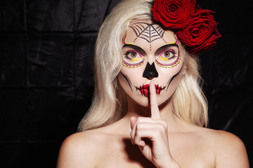 Halloween Make-Up Style. Blond Model Wear Sugar Skull Makeup with Red Roses. Santa Muerte Concept....