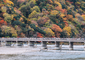 Fototapeta na wymiar Kyoto, Japan - November 19, 2018: Beautiful Togetsukyo bridge in Arashiyama Kyoto Japan in autumn season .